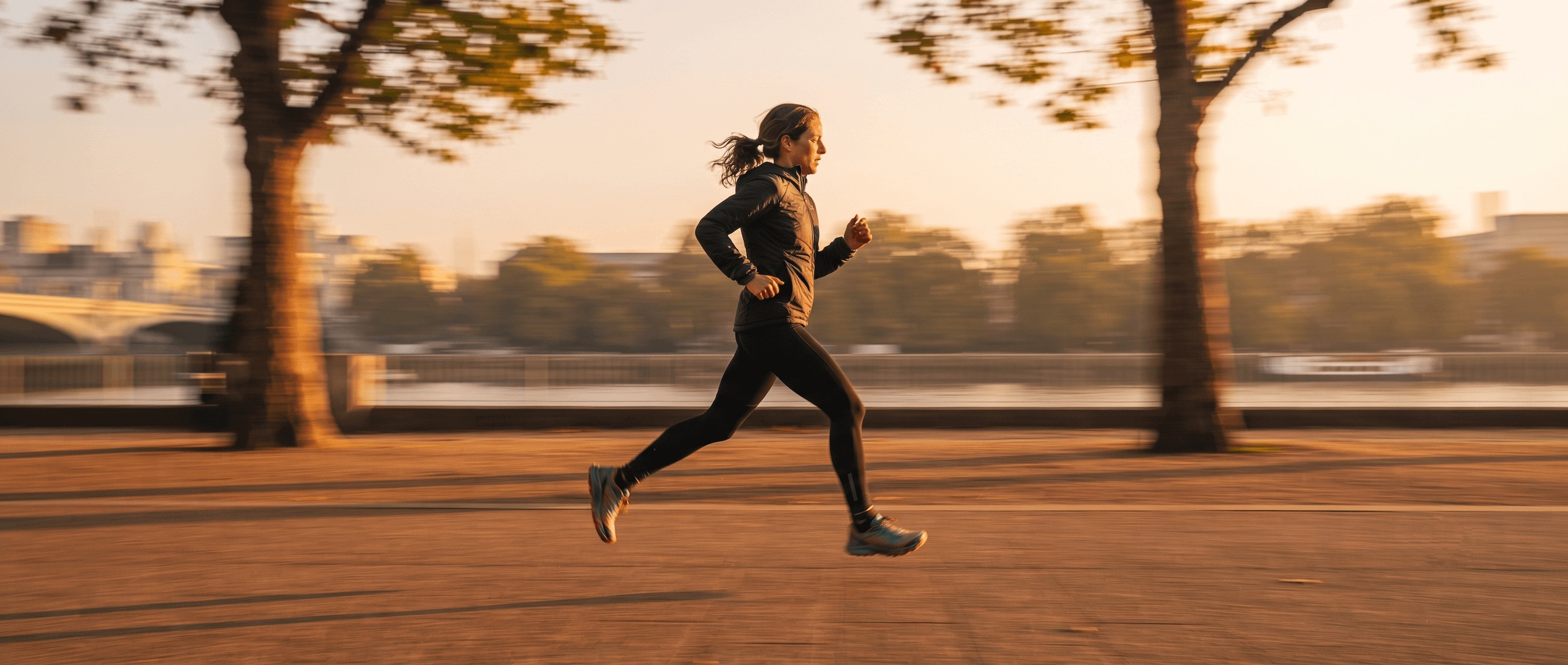 Side profile of a runner mid-stride at golden hour